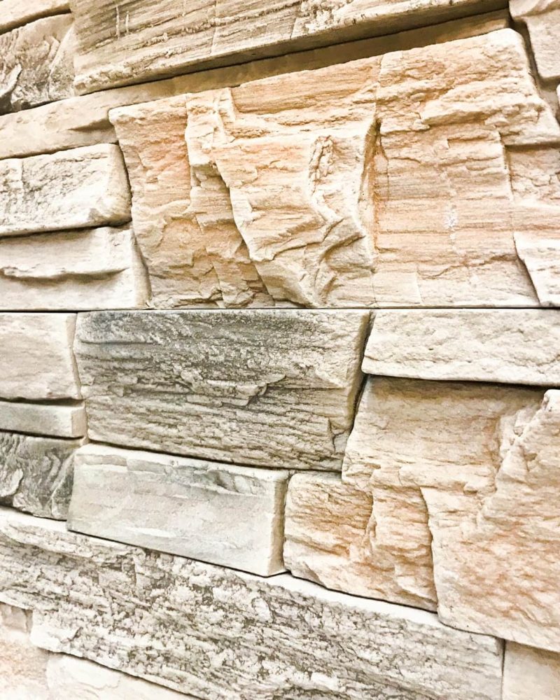 Beautiful texture of a decorative stone wall at an angle of construction gray textured relief stone with plaster with seams. The background.